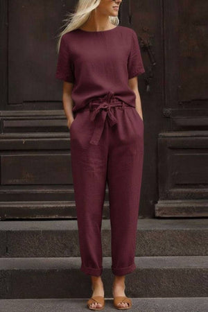 Woman wearing relaxed fit cotton linen set with short-sleeve top and straight-leg pants in maroon color