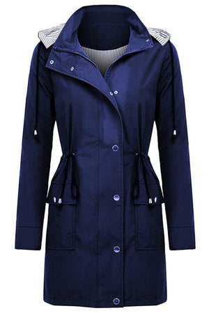 Women's navy water resistant windbreaker jacket with hood and striped inner lining, featuring oversized fit and multiple pockets.