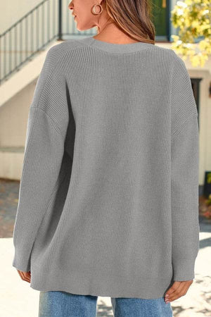 Back view of a woman wearing a gray relaxed fit oversized knitwear cardigan outdoors