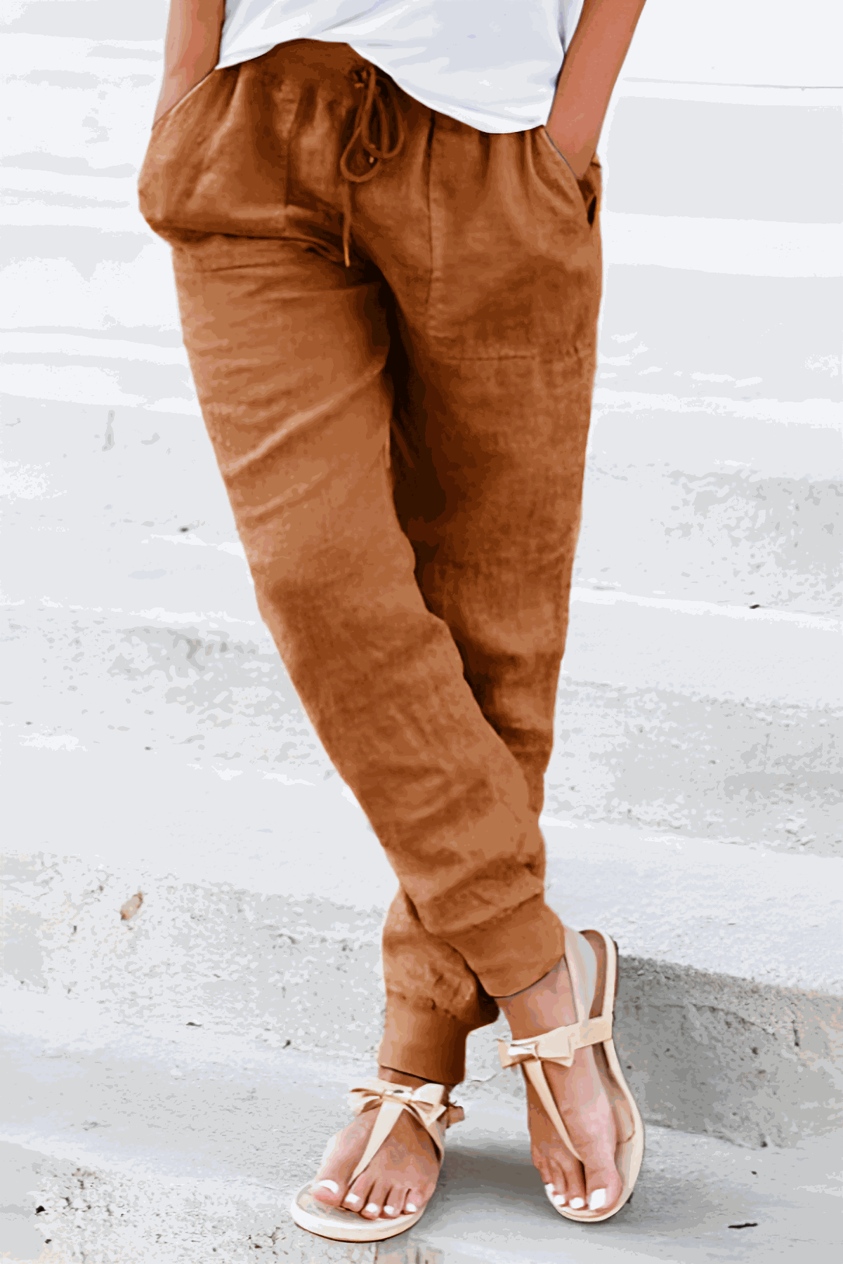 Women's relaxed chic elastic ankles pants in brown with drawstring waist and cuffed hems, styled with white top and sandals