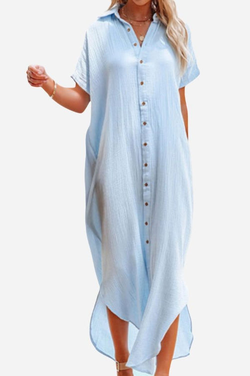 Light blue full-length button-down beach cover-up dress with short sleeves and collar, modeled on a woman.