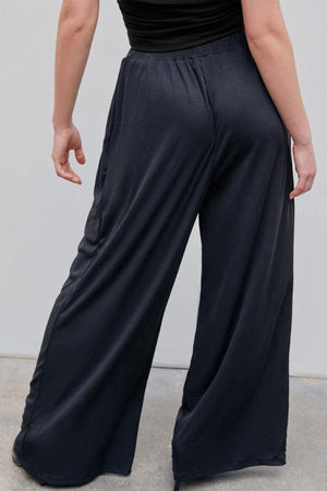 Back view of black stretchy wide-leg pants with elastic waistband for all-day comfort and flattering silhouette
