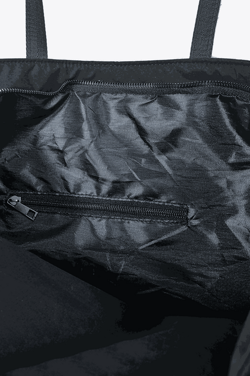 Interior view of black waterproof travel bag with zippered pockets and durable fabric lining