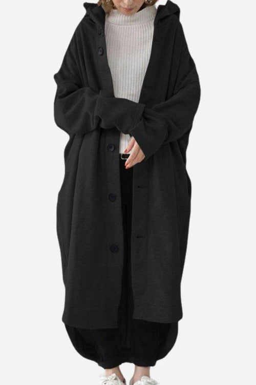 Oversized black buttoned hooded coat on person wearing casual outfit