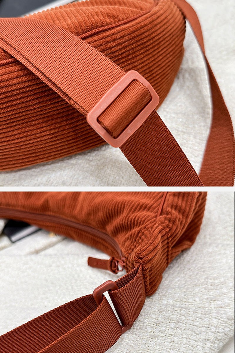 Close-up of adjustable strap and zipper on rust-colored corduroy shoulder bag