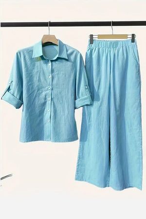 Light blue cotton blend two-piece set with button-up shirt and elastic waist pants hanging on wooden hangers