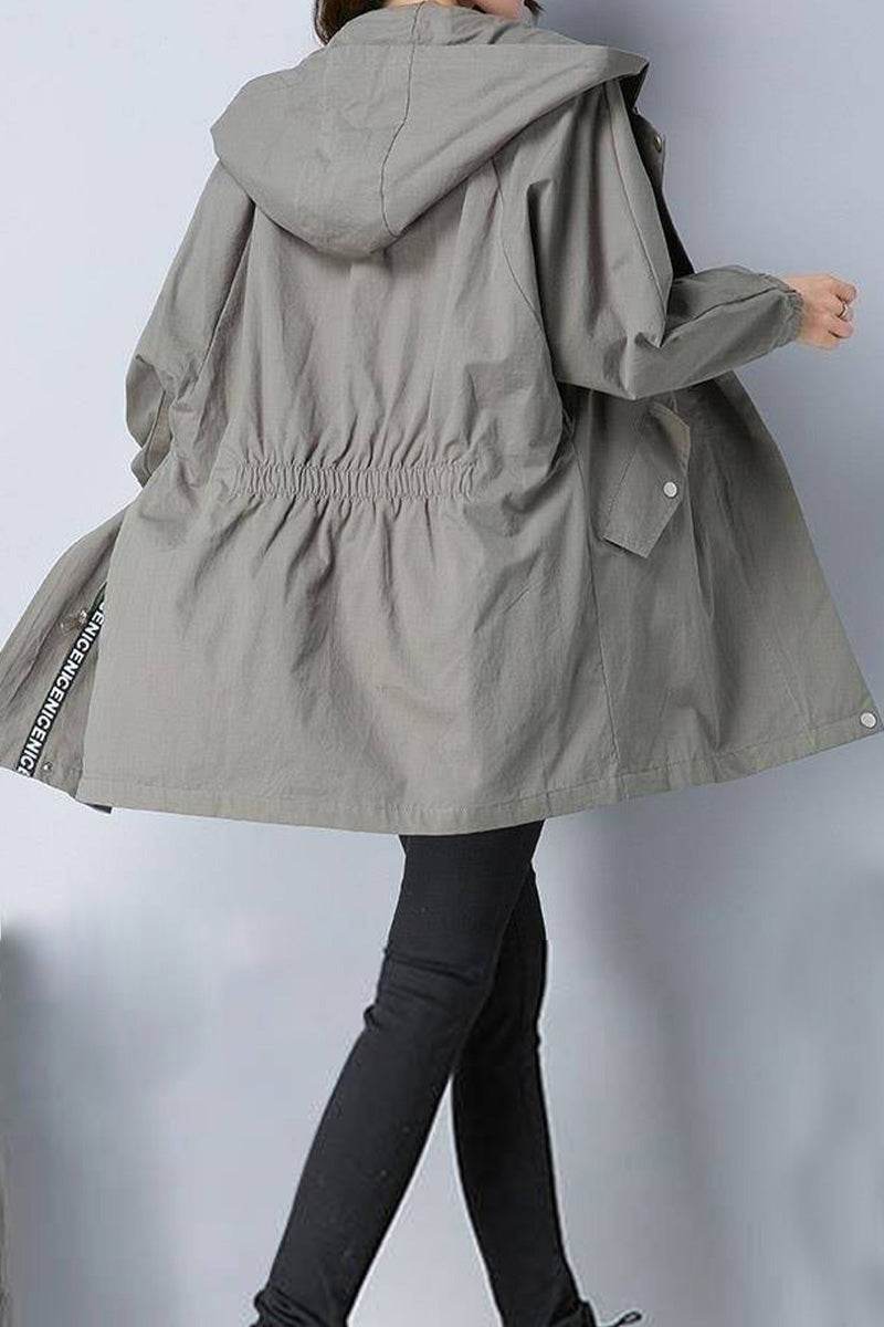 Back view of a gray fashion hooded trench coat with oversized silhouette and cinched waist, worn with black pants.