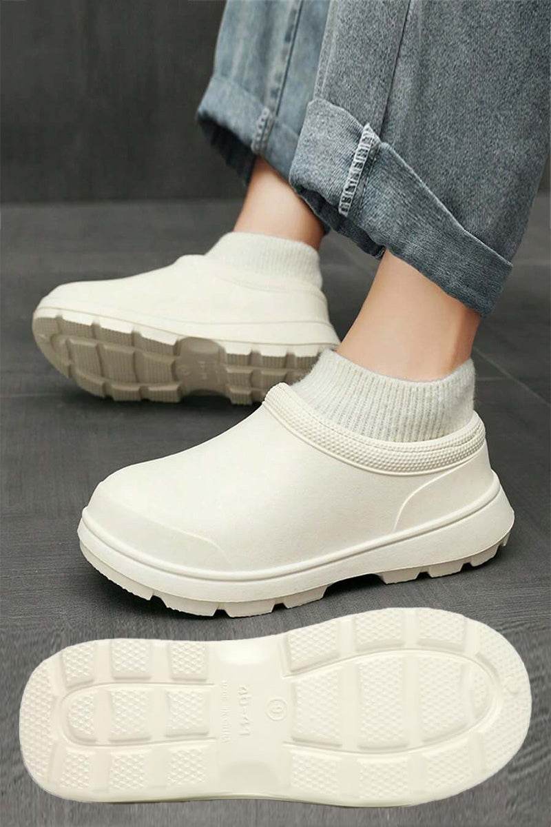 White fleece-lined comfort clogs with waterproof exterior and textured grip sole worn with rolled-up jeans