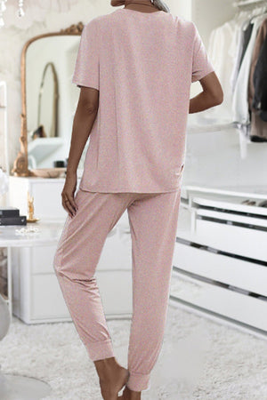 Back view of woman wearing pink ultra-soft two-piece loungewear set with batwing sleeves and jogger pants in cozy indoor setting
