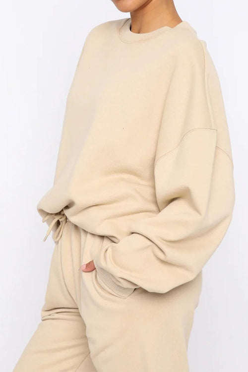 Woman wearing beige Classic Comfort Athleisure set with oversized sweatshirt and matching pants