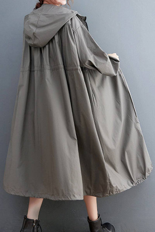 Oversized all-weather water-resistant windbreaker with hood, in neutral gray, worn over casual outfit.