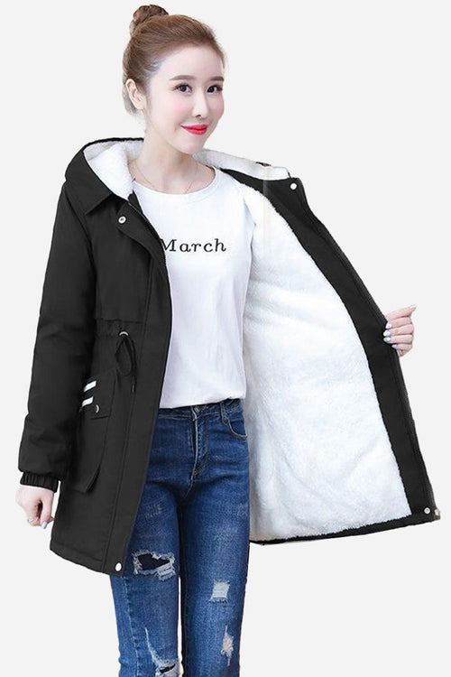 Cityscape Comfort Hooded Windbreaker with plush white fleece lining, black exterior, mid-length fit, and hood, modeled on woman wearing jeans and a white t-shirt.