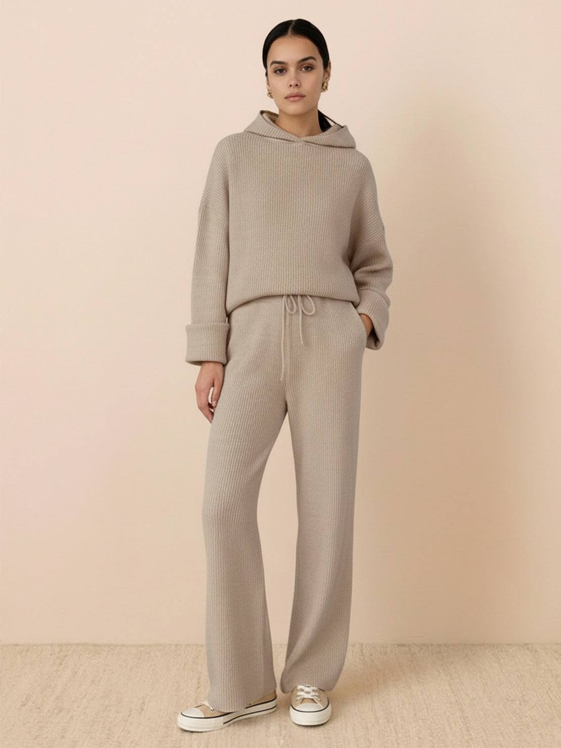 woman wearing beige waffle-knit two-piece hoodie and pants set standing against beige background