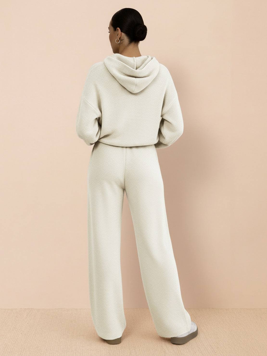 back view of woman wearing cream waffle-knit two-piece hoodie and wide-leg pants set