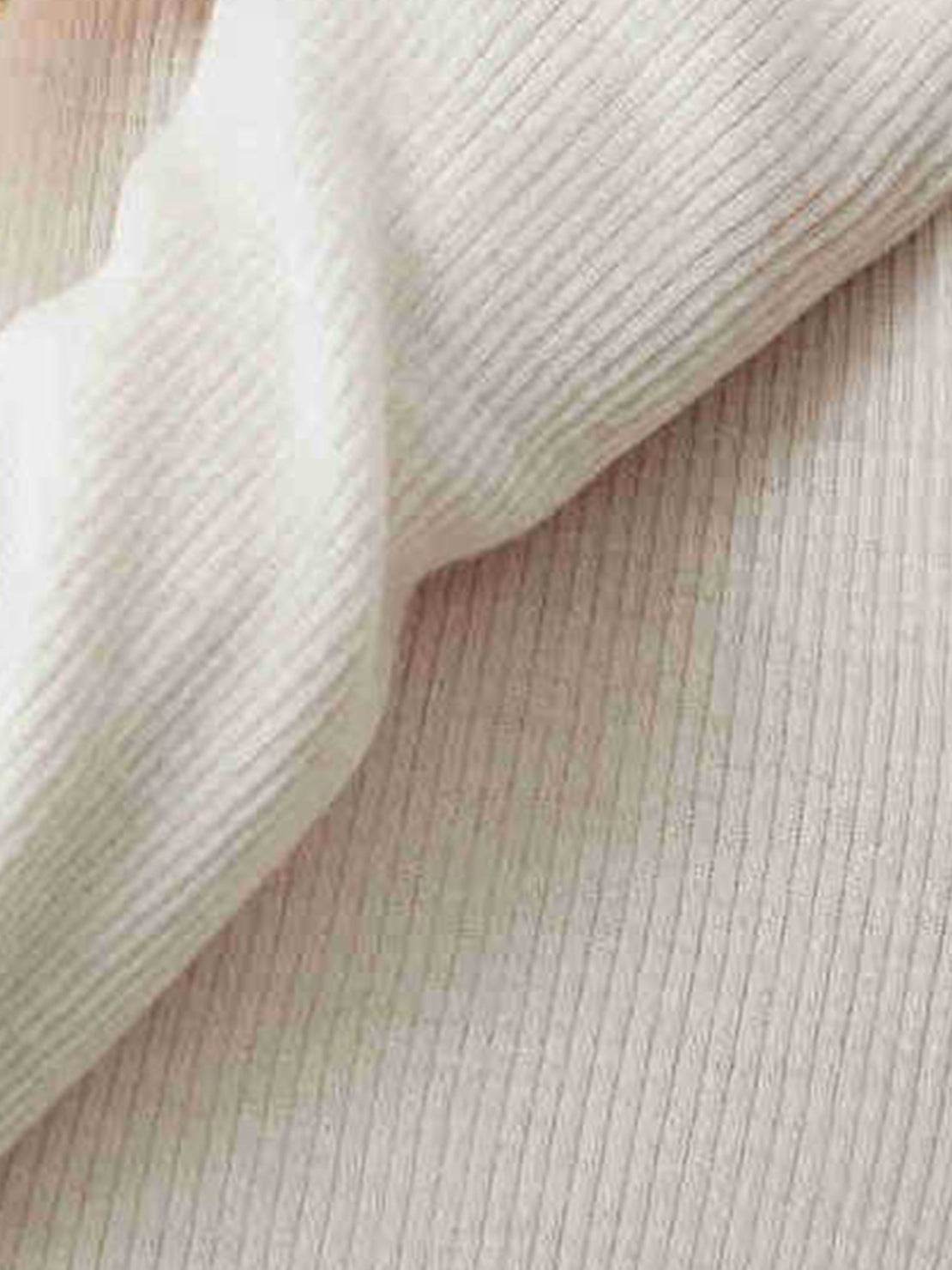 close-up of ribbed zip-up knit cardigan jacket with high neckline and fitted cuffs