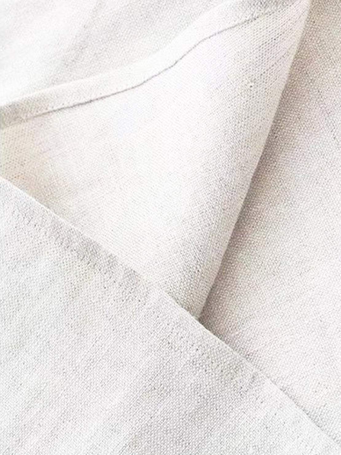 Cotton-linen sleeveless top with round neckline and button closure, relaxed A-line silhouette, hip-length design, natural fabric blend.