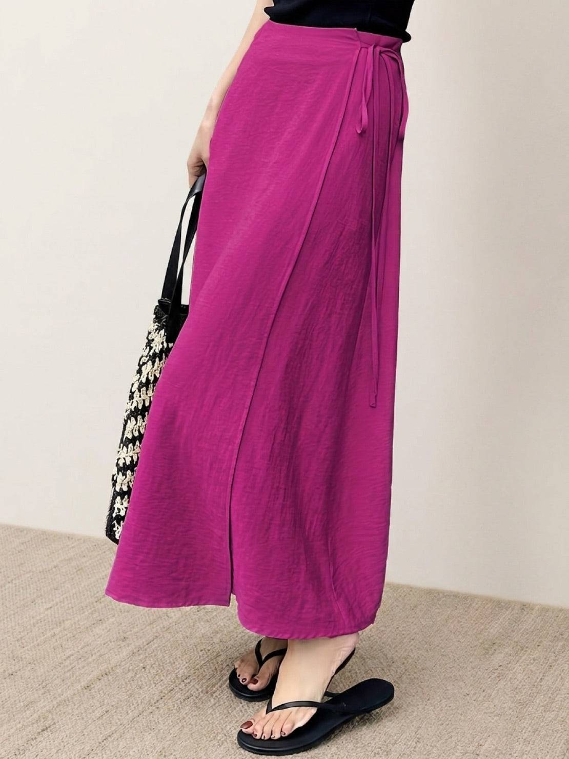 Woman wearing asymmetrical wrap maxi skirt with side tie closure and flowing hem