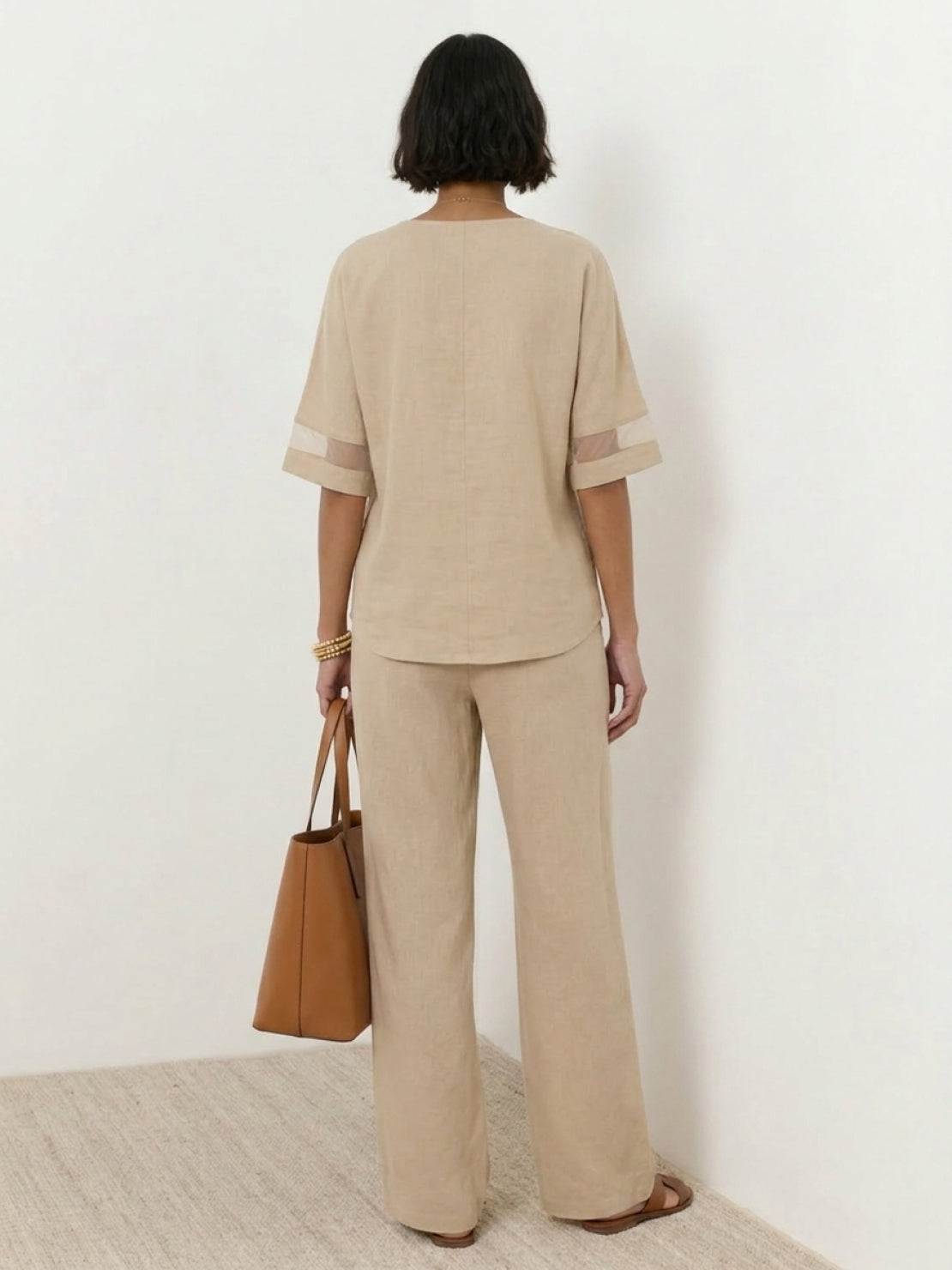 Mature woman wearing lightweight linen top with V-neck and button detail