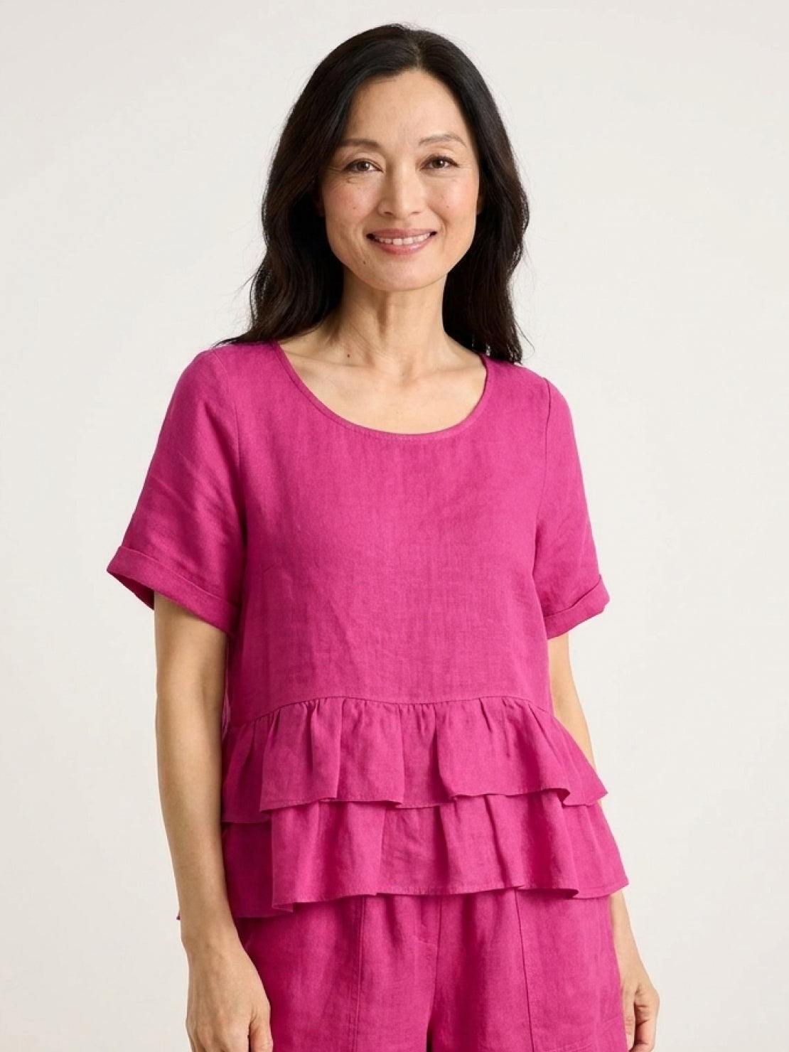 Woman wearing navy blue cotton relaxed shorts and matching short sleeve top with ruffle hem detail in a two-piece co-ord set