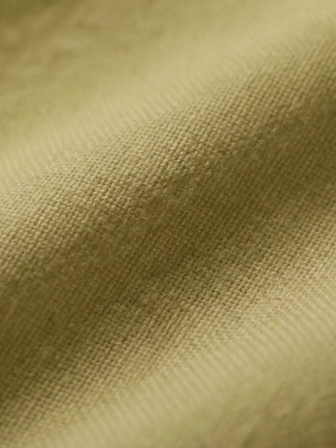 Close-up of soft mid-weight cotton fabric in mustard color for short-sleeved pullover and wide trouser matching set