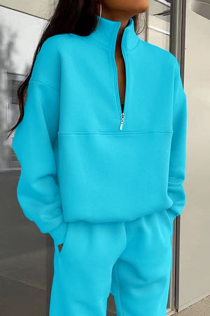 Woman wearing bright blue Classic Airplane Set two-piece tracksuit with high collar and zipper neck