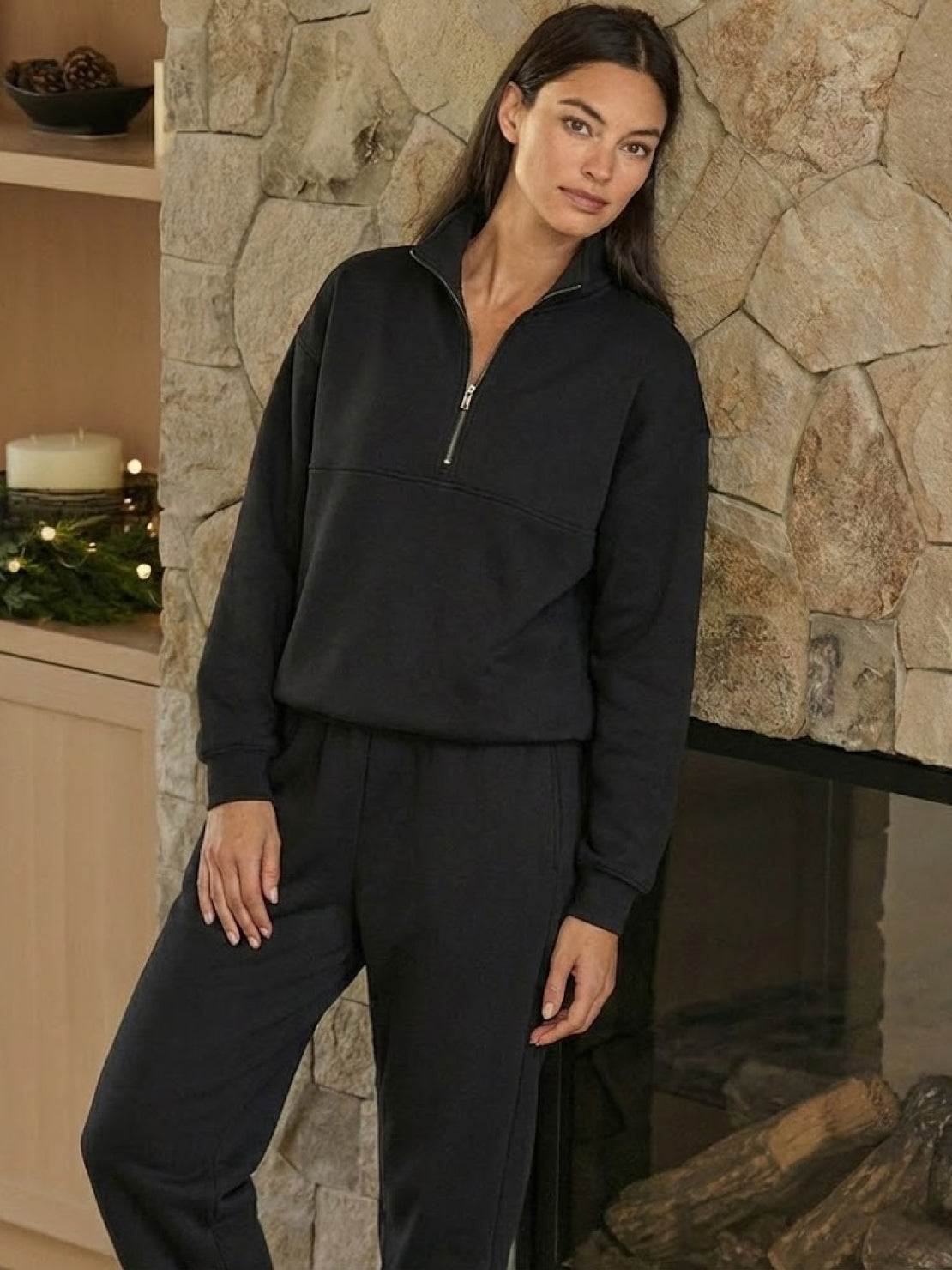 Woman modeling a cotton-blended two-piece tracksuit with high collar and deep zipper, styled for casual confidence and comfort.