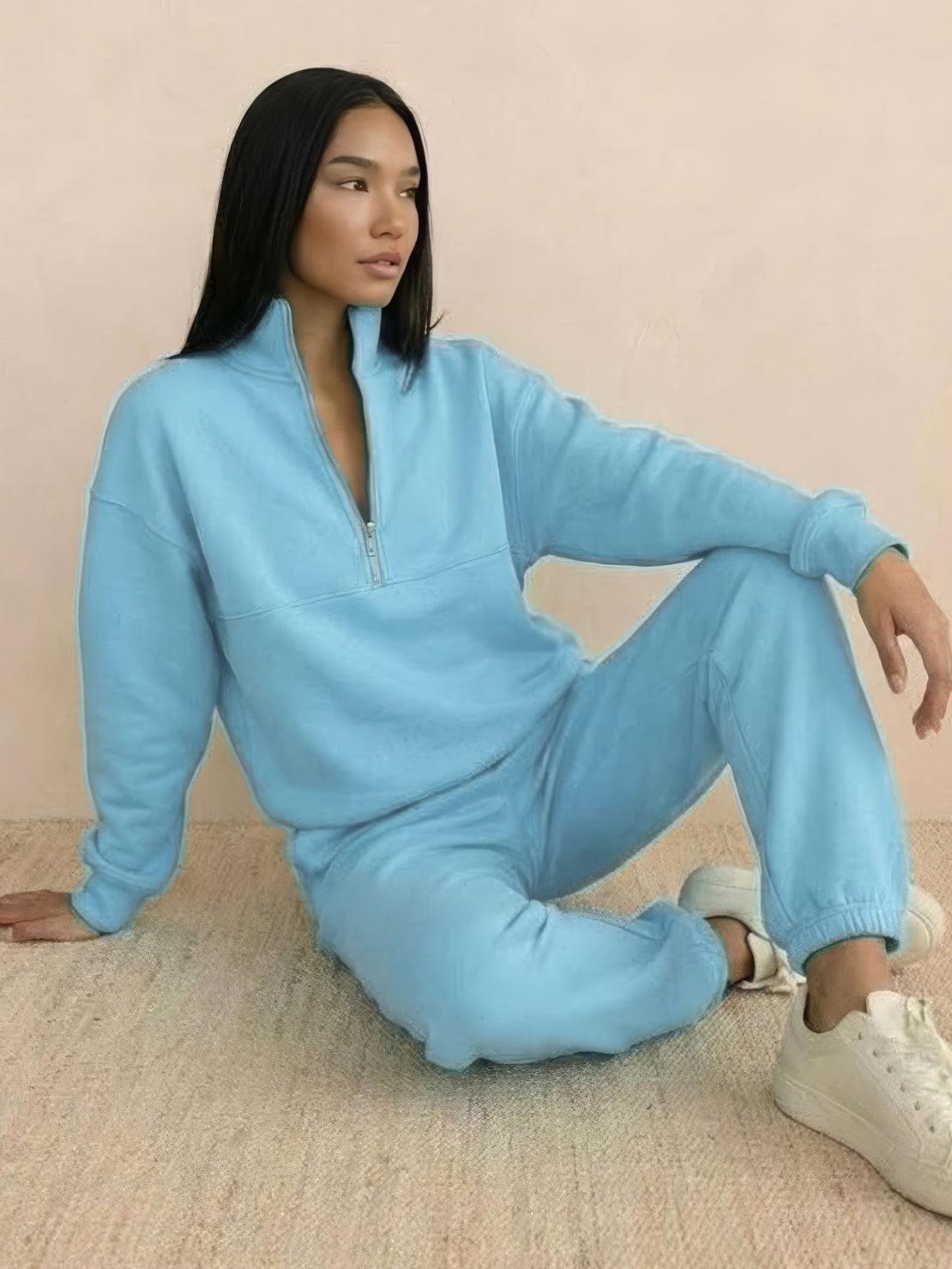 Woman wearing a cotton-blended two-piece tracksuit with high collar and deep zipper, showcasing casual comfort and style.