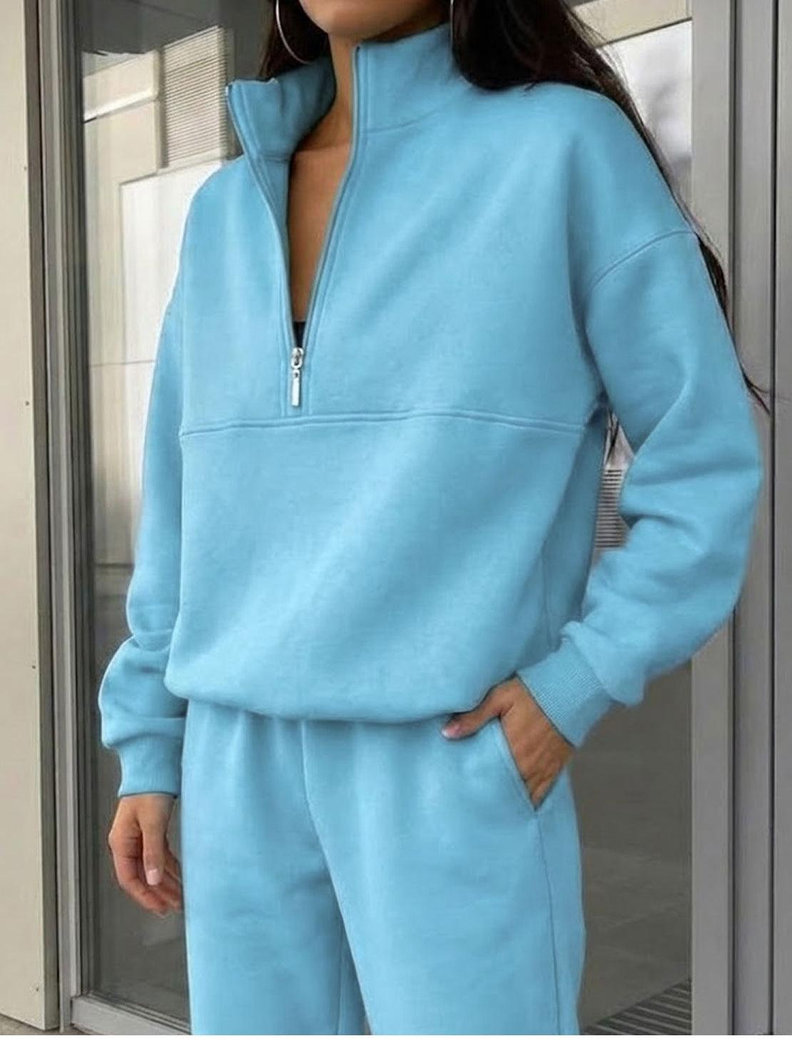 Woman wearing a cotton-blended two-piece tracksuit with high collar and deep zipper, styled for casual confidence and comfort
