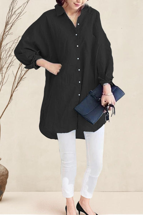 Black oversized linen shirt with relaxed fit and button details worn with white pants and black heels