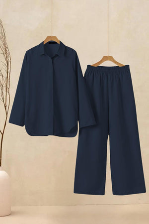 Navy oversized 100% cotton shirt and wide-leg pants co-ord set hanging on beige wall background