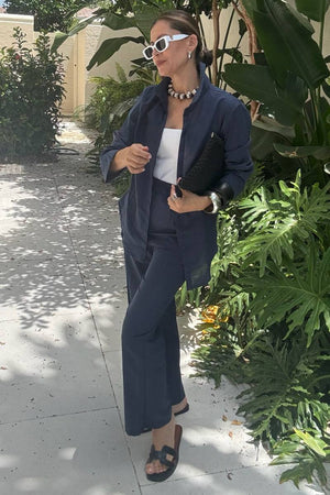 Woman wearing oversized 100% cotton navy shirt and wide-leg pants co-ord set with sunglasses and accessories outdoors