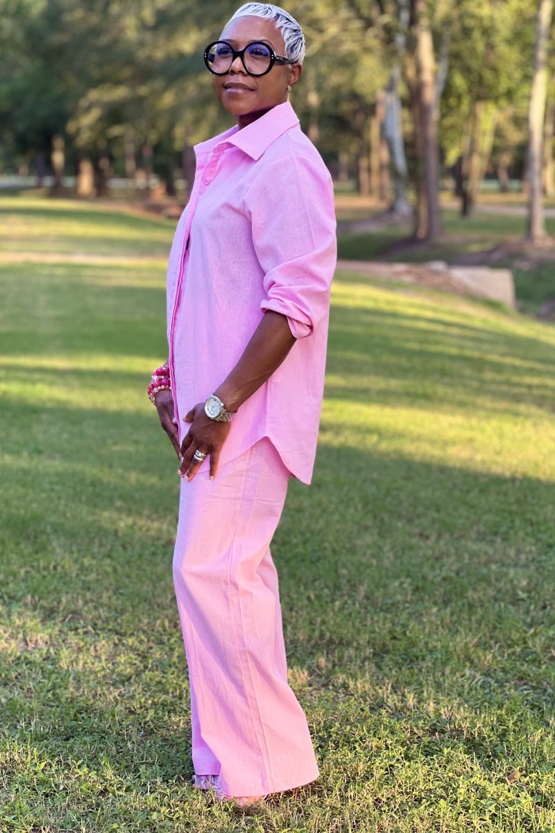 Woman wearing oversized 100% cotton pink shirt and wide-leg pants co-ord set outdoors