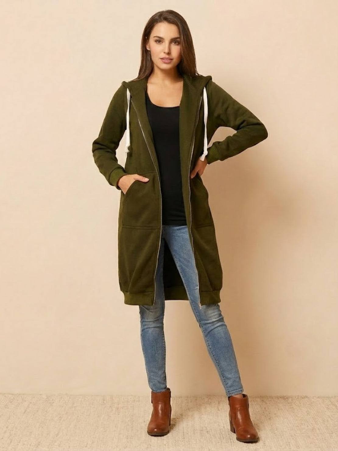 Woman wearing oversized long zip sweatshirt hoodie in olive green with front pockets and hood