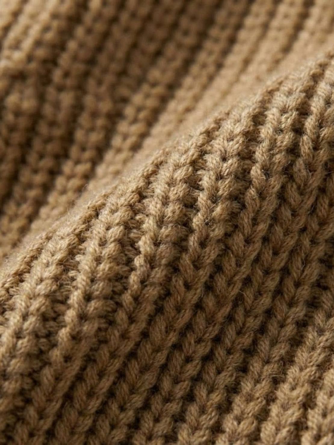 Close-up texture of relaxed fit oversized knitwear cardigan fabric in warm brown color