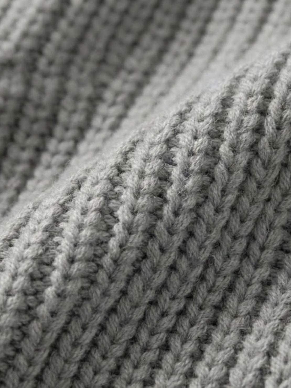 Close-up of grey relaxed fit oversized knitwear cardigan fabric texture
