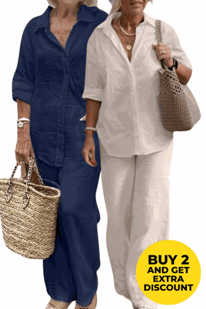 Two women wearing relaxed shirt and trousers two-piece sets in navy blue and white colors, casual loose fit, holding woven bags.