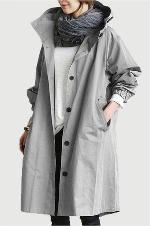 Gray oversized Rain Couture Windbreaker with hood and buttons, worn layered over casual outfit.