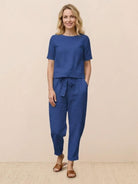 Woman wearing relaxed 100% cotton linen set with monochrome short-sleeve top and straight-leg pants on white background