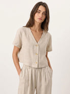 Lightweight 100% linen French top with relaxed boxy fit, V-neckline, short sleeves, and three-button front in light khaki color