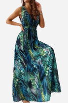 Woman wearing a casual sleeveless dress with green and blue tropical leaf print