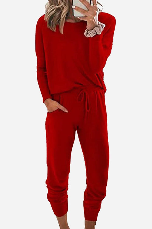 Woman wearing red Cozy Chic Two-Piece Sweatsuit set with long-sleeve top and high-waisted pants with pockets