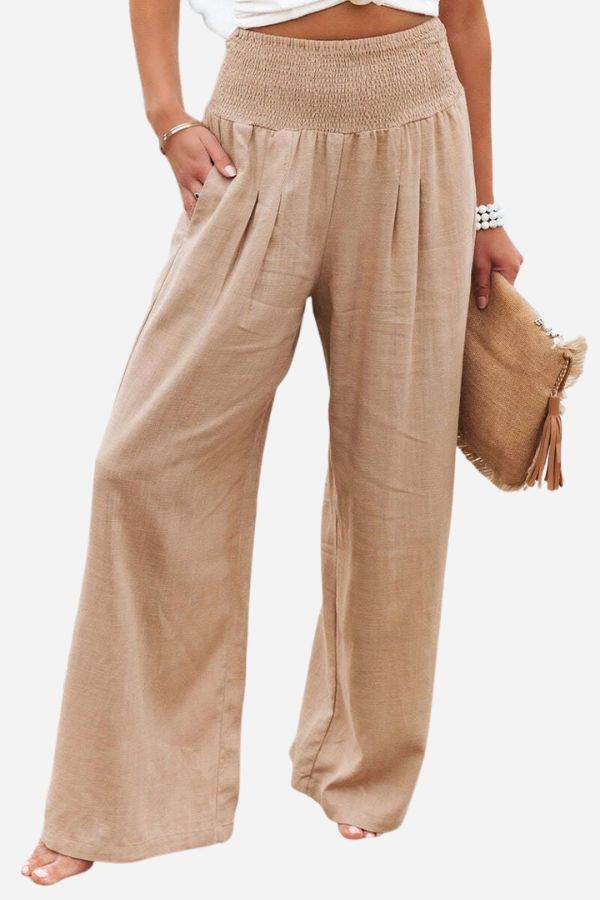 High-waist cotton linen palazzo pants in beige with wide legs and pockets, styled with a white top and beige clutch.
