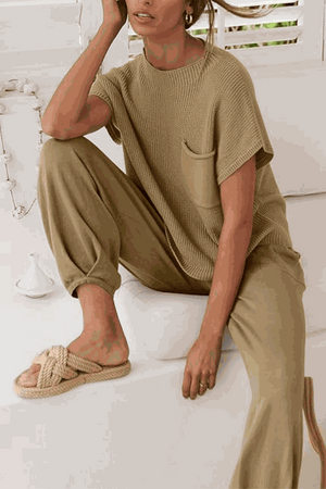 Woman wearing Comfy Couture Knit Sweater and matching high-waisted pants set in beige tones sitting casually indoors