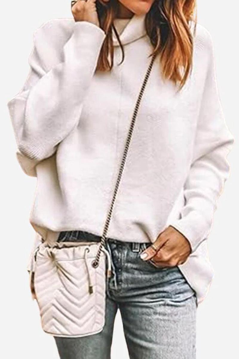 Woman wearing white Cozy Oversized Knit Pullover with light gray jeans and small quilted crossbody bag