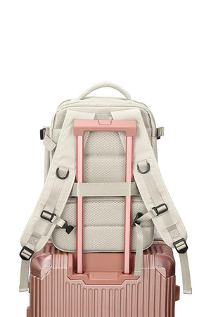 Chic Wanderlust Waterproof Backpack shown attached to a pink rolling suitcase handle, highlighting ergonomic back and adjustable straps.
