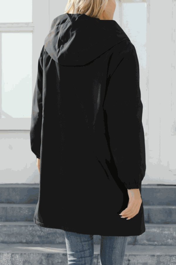 Black water-resistant windbreaker jacket with hood and elastic waist, shown from back on woman indoors