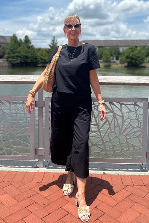 woman wearing black loose fit co-ord set with short sleeves and wide-leg pants outdoors