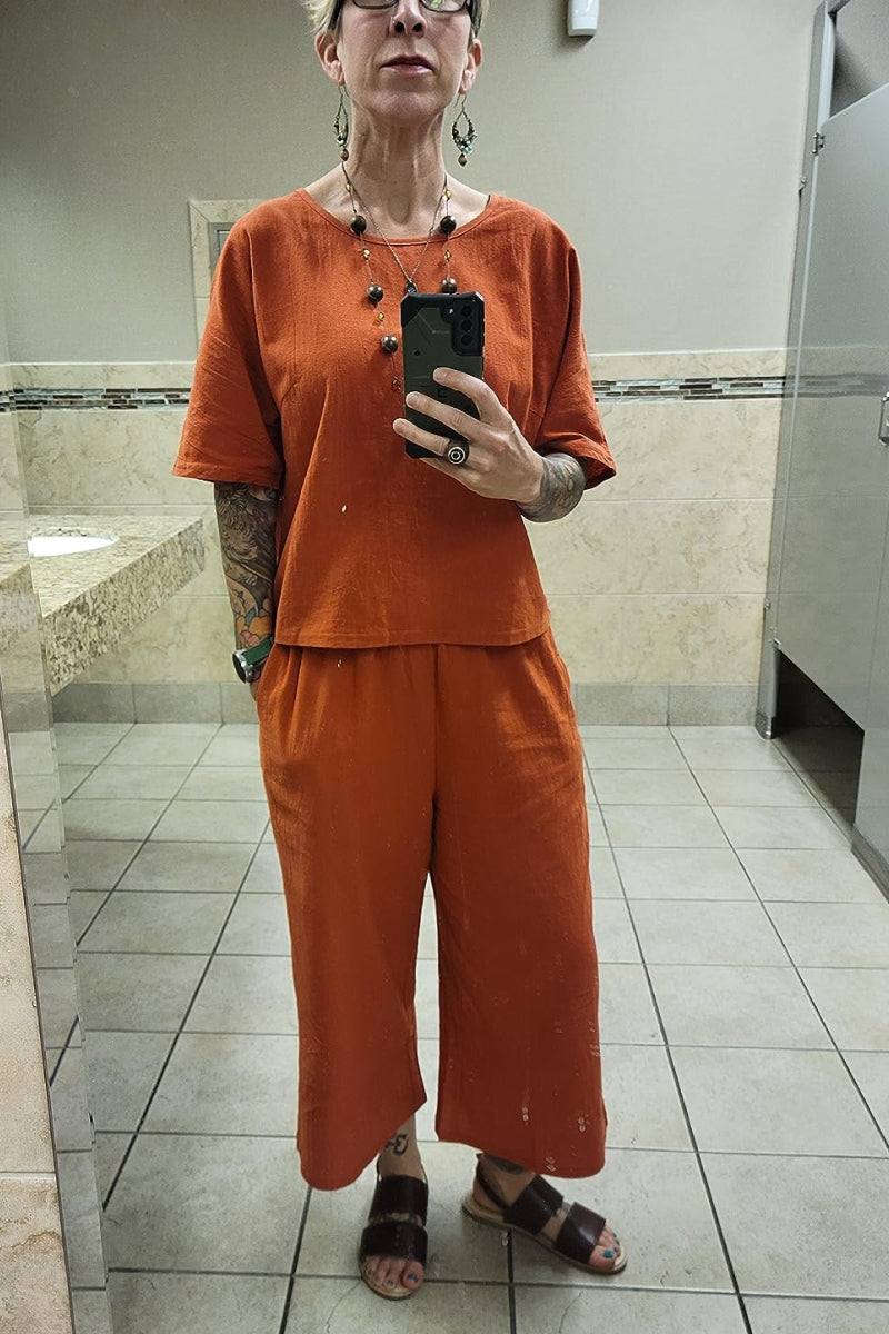 Orange loose fit co-ord set with relaxed short sleeve top and wide-leg cropped pants in breathable fabric.