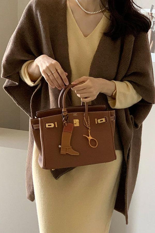 woman wearing relaxed flowy open front knitwear cardigan with beige dress and brown handbag