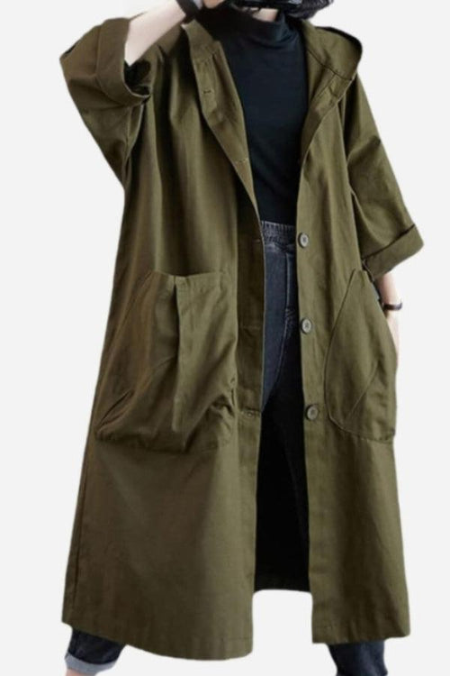 Oversized olive green water resistant windbreaker jacket with large pockets and button front, styled over black clothing